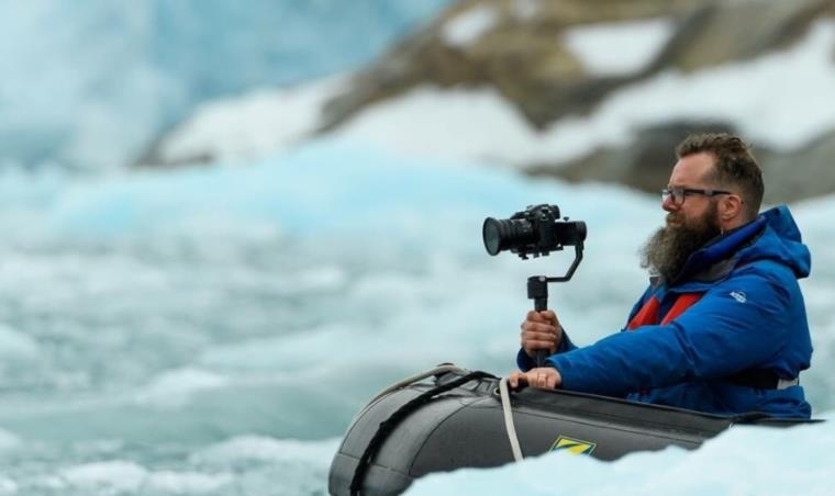 Doctoral student, Adam Laity, filming in the Arctic landscape.
