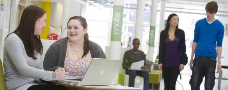 Two students talking together in a campus setting.