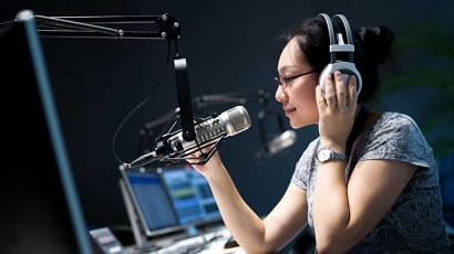 A student speaking into a microphone in a radio studio