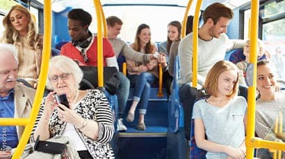 A bus is full with passengers as it travels along.