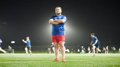 UWE Bristol rugby player Louis James stands on a rugby pitch with his arms folded