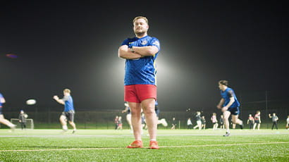 UWE Bristol rugby player Louis James stands on a rugby pitch with his arms folded
