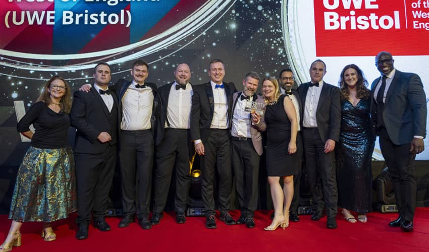 A group of people standing on a stage smiling. 