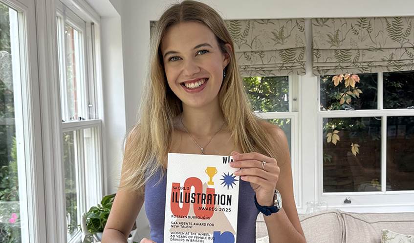 A woman smiles proudly holding an award certificate.