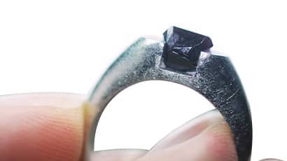 A close up photo of a platinum ring viewed from the side, with a ruby setting which has been grown in situ 