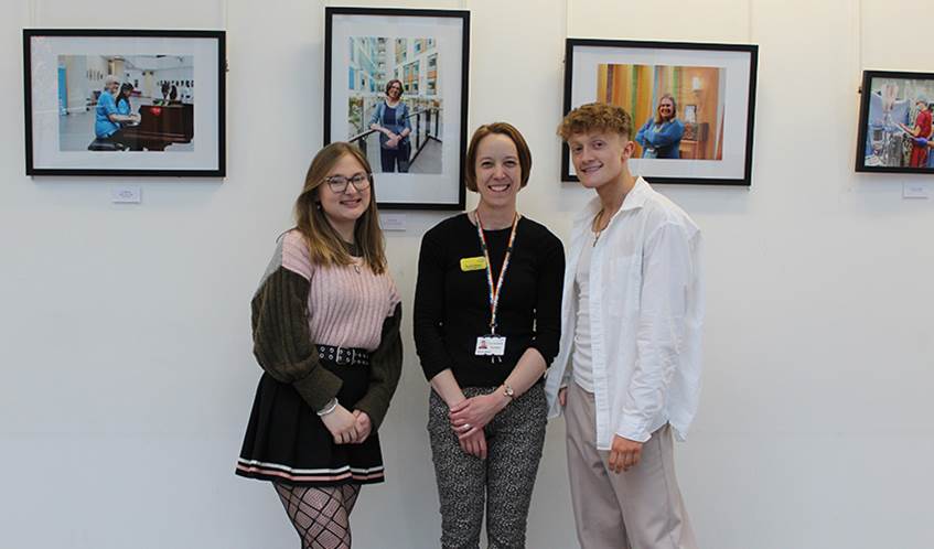 Students Carla Mabb and Kian Swainston, with arts programme manager Donna Baber standing in front of the photography exhibition at the Brunel building