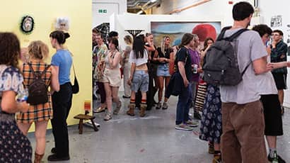 A large group of people browse an art centre