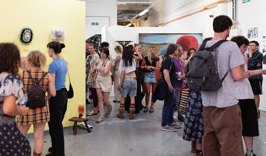 A large group of people browse an art centre.