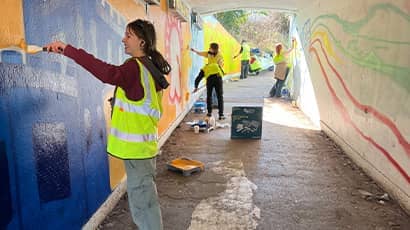 An underpass gets a makeover with a group of students painting a colourful mural. 
