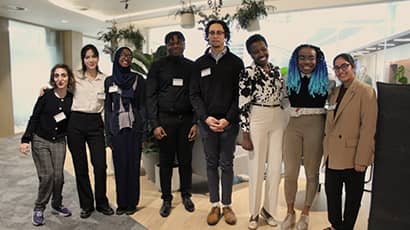A group of young professionals gathered in a corporate office setting 