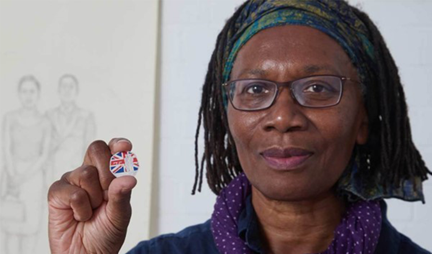 Valda Jackson holding up the coin she designed
