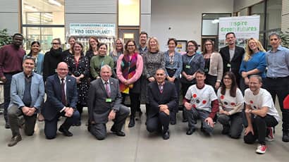 A large group of people gathered looking at the camera, with some crouched at the front. 