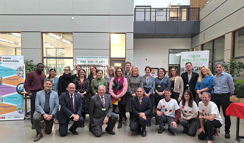 A large group of people gathered looking at the camera, with some crouched at the front. 