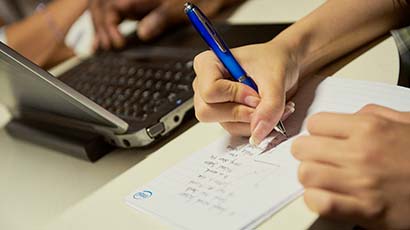 Close up of a student writing on paper