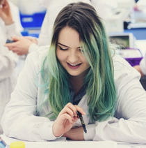Smiling student in a lab coat