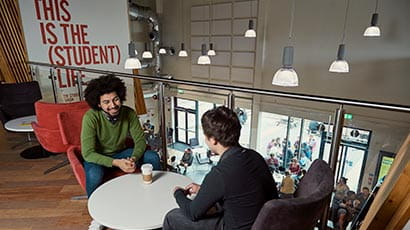 Two people talking over a coffee