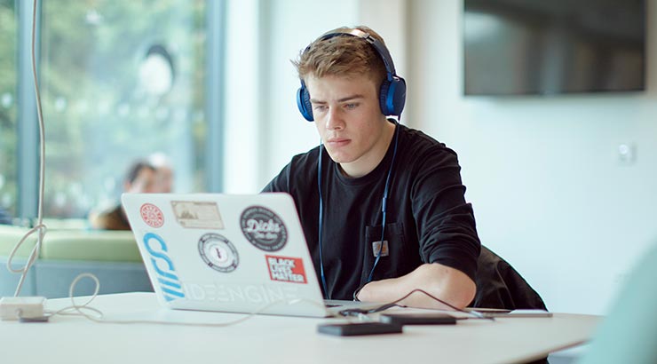 Student working at a laptop in study space