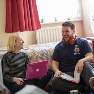 Two students laughing together in university accommodation