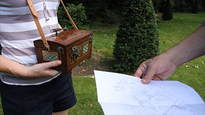 Person holding a box and a paper map.