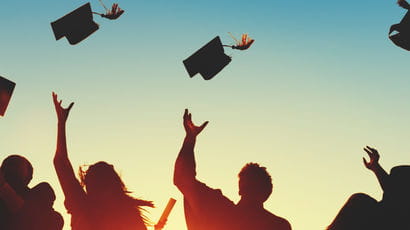 Graduating students throwing caps in the air.