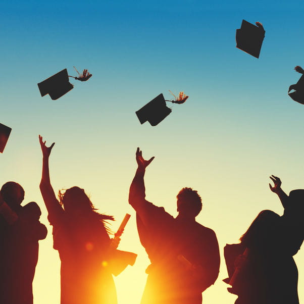 Graduating students throwing caps in the air.