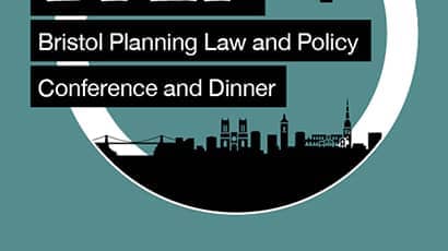 Illustration of a human hand holding a half sphere of Bristol's landmarks (Clifton Suspension Bridge, Bristol Cathedral and row of coloured houses) against a backdrop of white clouds and blue skies, with hot air balloons.