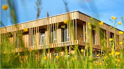 A modern and sustainable home against a bright blue sky.