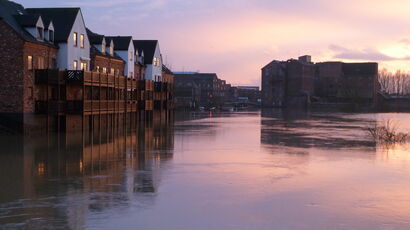 An image depicting a flooded residential area in low light. 