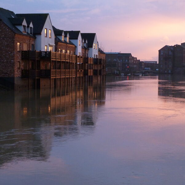 An image depicting a flooded residential area in low light. 