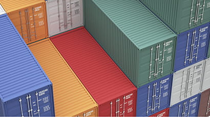 Multi-coloured shipping containers of blue, orange, green and white piled on top of each other.