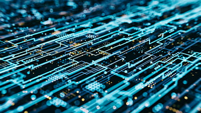 Computer circuitry in neon blue colours against a dark board.