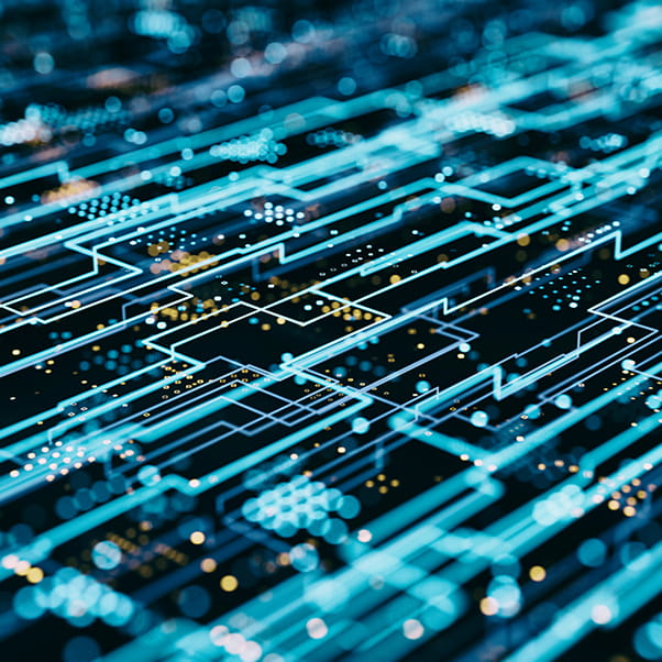 Computer circuitry in neon blue colours against a dark board.