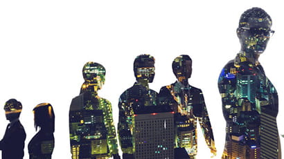 Silhouettes of business people against a backdrop of a night time city skyline.