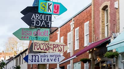 Image of a colourful multi-sign signpost pointing in different directions in Bristol.