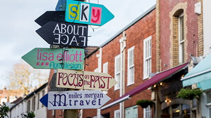 Image of a colourful multi-sign signpost pointing in different directions in Bristol.