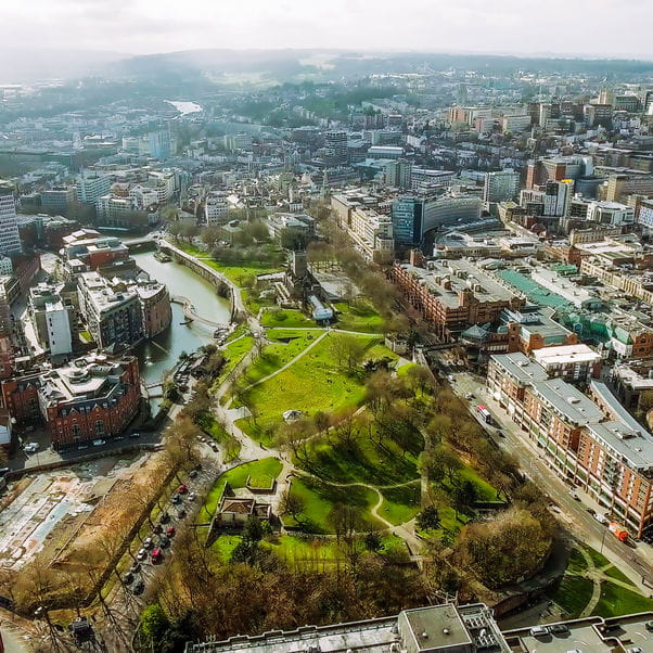 Aerial panaromic shot of Bristol City Centre with a river running alongside a large green park.