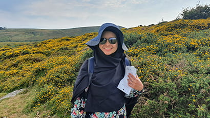 Image of FET postdoctoral research student, Thanti Octavianti, against a backdrop of a blue sky and hilly countryside.