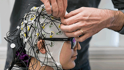 Closeup of hands adding wires to someone's head.