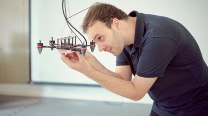 Student adjusting a small piece of machinery.