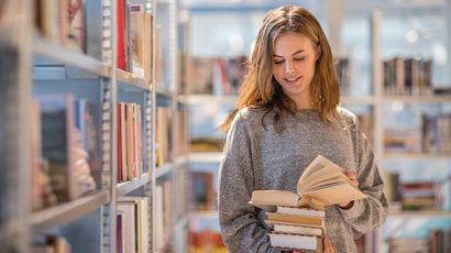 Researcher looks through books in a library