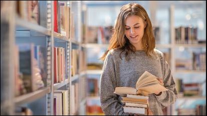 Researcher looks through books in a library