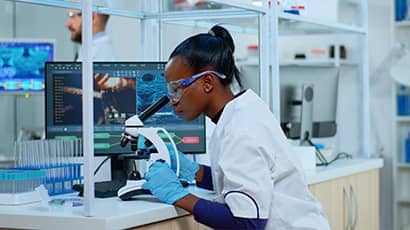 Researcher in a lab using a microscope