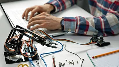 Robotics engineer testing and reporting on a robotic arm.