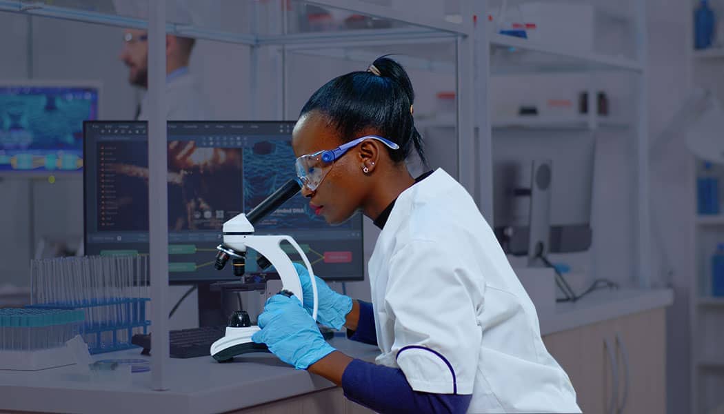 Researcher in a lab using a microscope