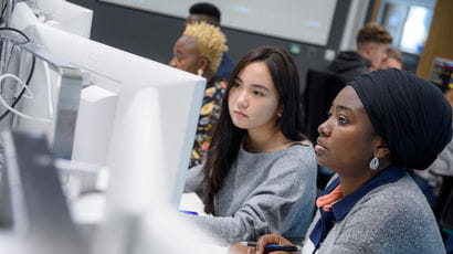 Students working on computers in a study room.