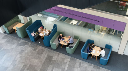 People working in break-out areas in the Bristol Business School.