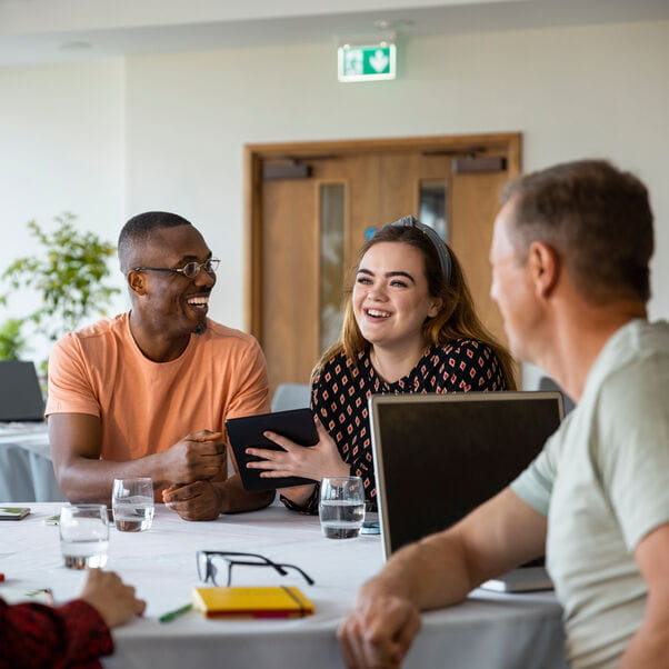 Group of researchers attending a workshop together, having a discussion around a table.