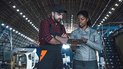 Discussion between a man and women looking at a tablet.