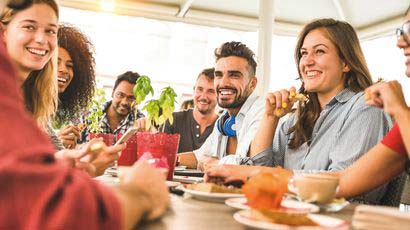 People sat around a dinner table smiling.