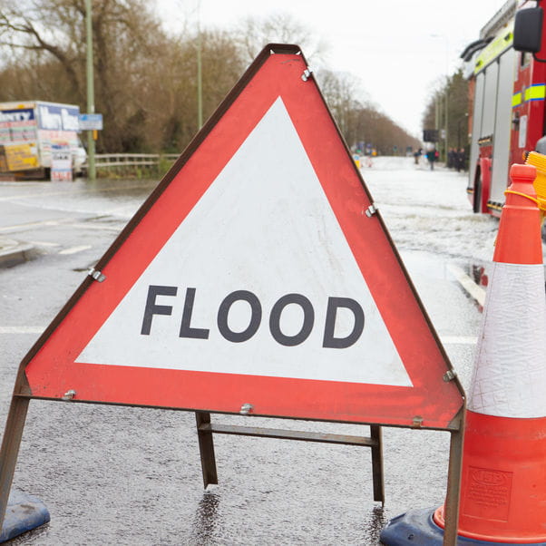 A flood sign out on a street.